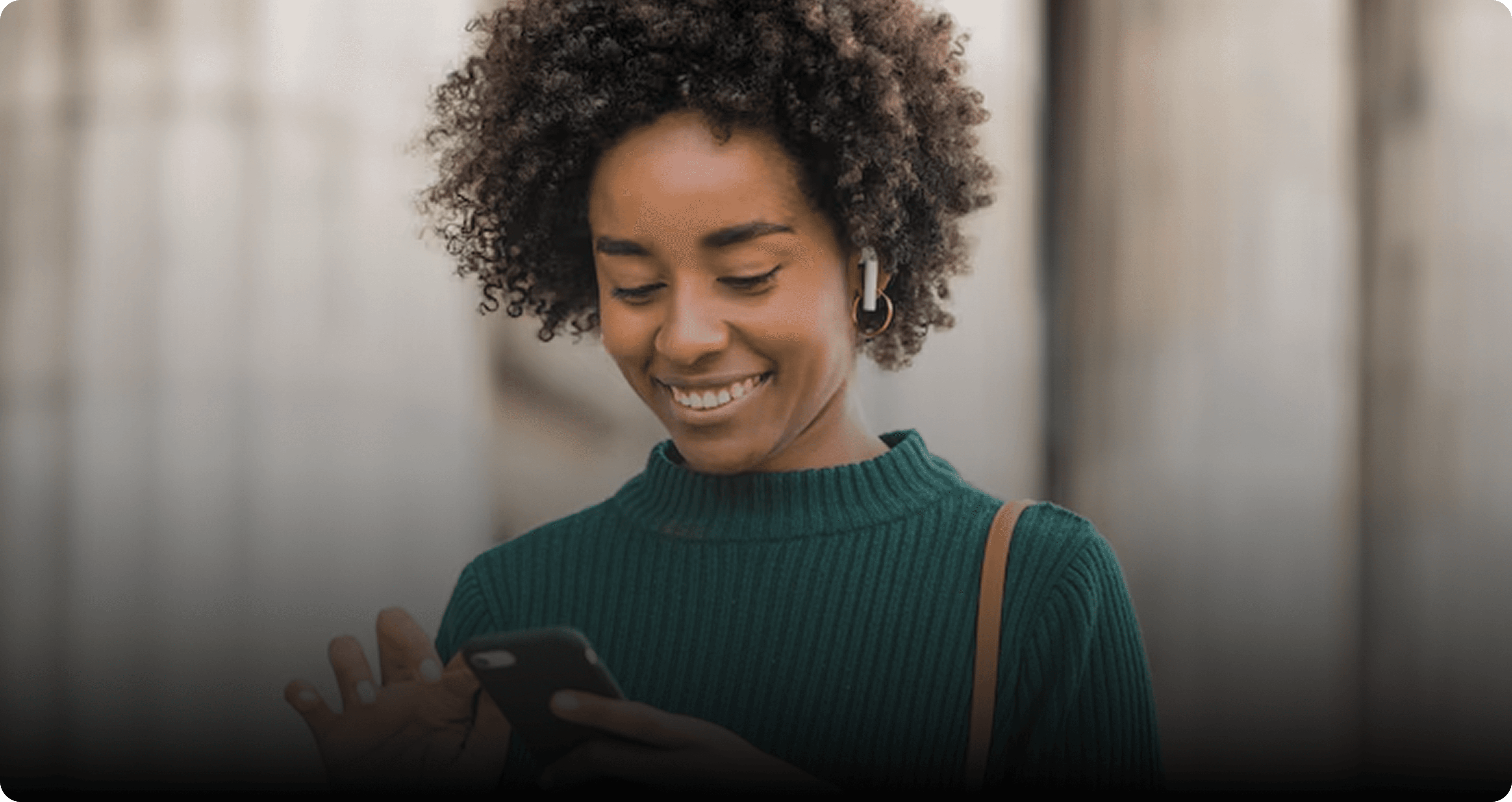 Femme souriante consultant sur son smartphone le suivi de ses demandes de remboursement